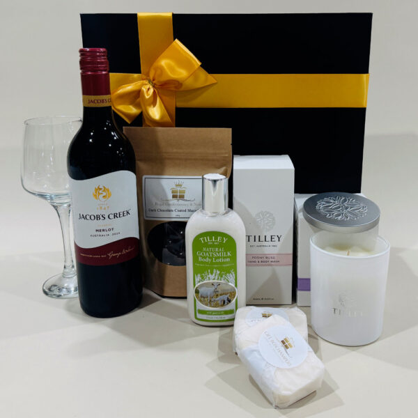 Pamper Hamper With Red Wine image. Goats milk lotions & soaps scented soy candle chocolate coated macadamias & classic red wine Ph 03-5174-4888.